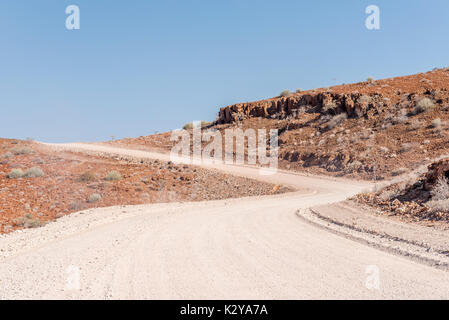 The orange-red, rocky Namib desert landscape at Dopsteekhoogte Pass on the C39-road to Torra Bay, in the Kunene Region of Namibia Stock Photo