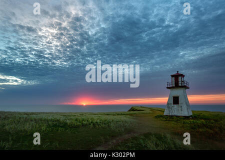 Cloudy sunrise over Cap Alright lighthouse at Havre-aux-maisons on Magdalen Islands, Quebec Stock Photo