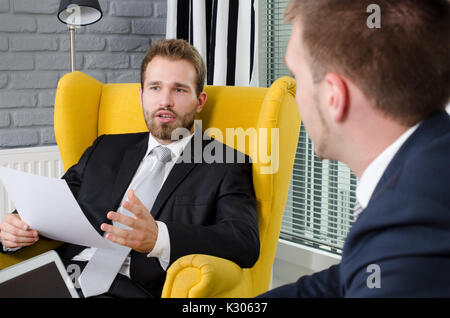 Two focused business partners talking in a modern office Stock Photo