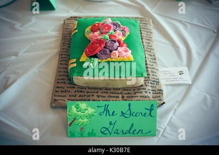 Submission for Read It and Eat It contest, and edible book festival at Milton S Eisenhower Library, Johns Hopkins University, showing a cake made of a green book with flower bouquet from frosting, and a page of text underneath, for the theme 'The Secret Garden, ' Baltimore, Maryland, April, 2016. Courtesy Eric Chen. Stock Photo