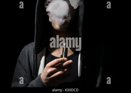 Young man vaping an electronic cigarette. Stock Photo