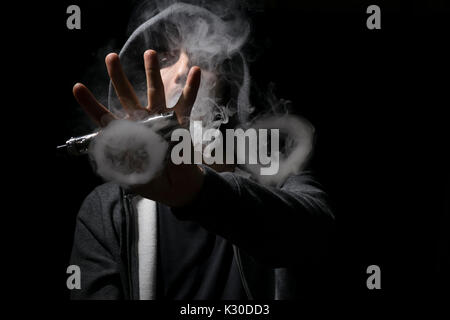 Young man doing vaping tricks circles. Stock Photo