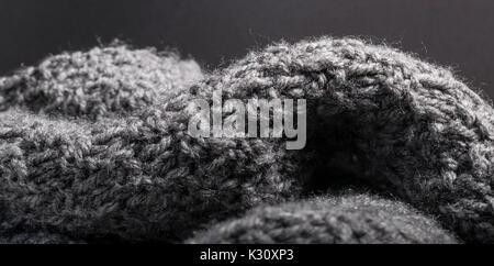 Isolated knitted cashmere wool fabric on a dark background in details. Stock Photo