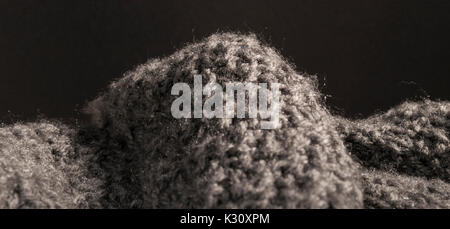 Detailed abstract knitted cashmere wool fabric Isolated on a black background. Stock Photo