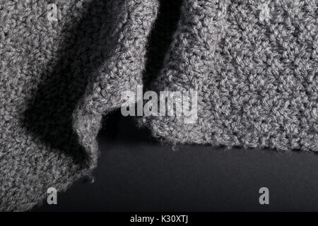 crumpled handmade gray fabric on a dark background. Stock Photo