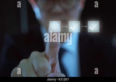 Business process workflow illustrating management approval, flowchart with businessman in background Stock Photo