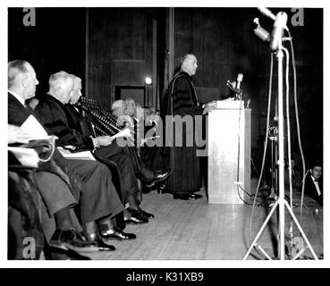 President of Johns Hopkins University Milton S. Eisenhower speaks at a podium during the university's Commemoration Day in 1957, celebrating the anniversary of the university's founding, February 22, 1957. Stock Photo