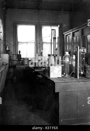 Grayscale photograph of interior of a second floor Physical Chemistry laboratory, with glassware and other instruments at wooden lab tables, from the Chemical Laboratory in Old Campus at Johns Hopkins University, Baltimore, Maryland, 1924. Stock Photo