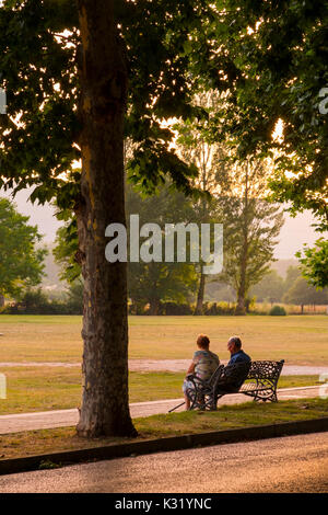 Elderly couple sitting on a bench at sunset in the park. Villarcayo. Burgos province, Castilla-León, Spain Europe Stock Photo