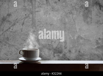 Cup of hot drinks with steam on wood table and concrete background, hot coffee, tea, chocolate and etc. Stock Photo