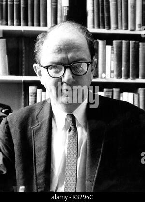 Portrait of American historian and biographer David Herbert Donald sitting in front of bookshelves, 1963. Stock Photo