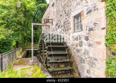 An ancient Scottish mill wheel still in operation and water powered in North Ayrshire in Scotland Stock Photo