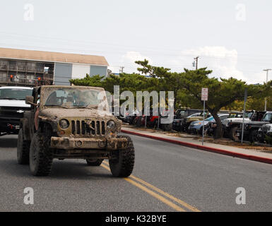 OCEAN CITY, MD - AUGUST 26, 2017: A vintage Jeep covered thick dried mud arrives at the Roland E. Powell Convention Center on Saturday afternoon of Je Stock Photo