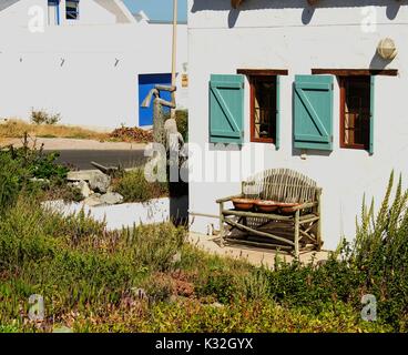 old wooden bench standing next to fishermen's white houses, selective focus Stock Photo