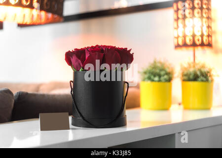 Roses in black box standing on the white table Stock Photo