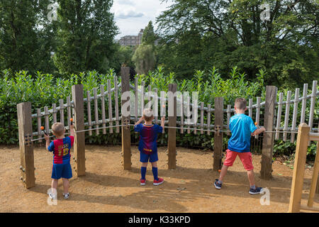 Young boys experiment with strike sound pipes to make musical notes in the Horniman Museum's Sound Garden, on 24th August 2017, Forest Hill, London, England. Stock Photo