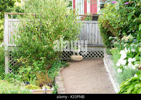 Karlskrona, Sweden - August 28, 2017: Travel documentary of garden cottage village. Garden path leading up to concrete cat and balcony, surrounded by  Stock Photo