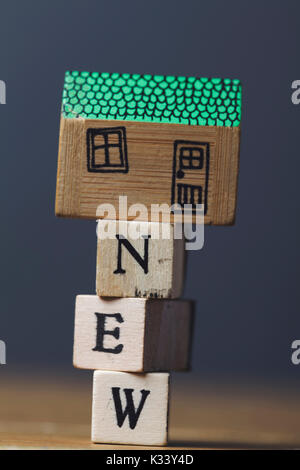 House model with cost word made from wooden blocks. Home finance concept Stock Photo