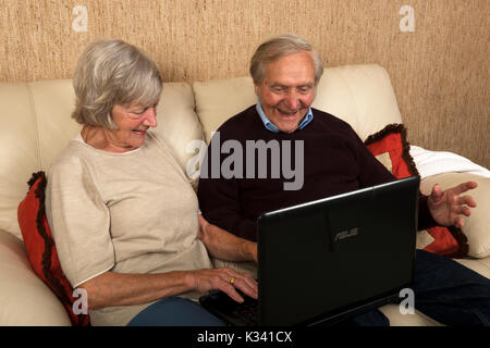 Elderly brother and sister using a laptop computer to send emails Stock Photo