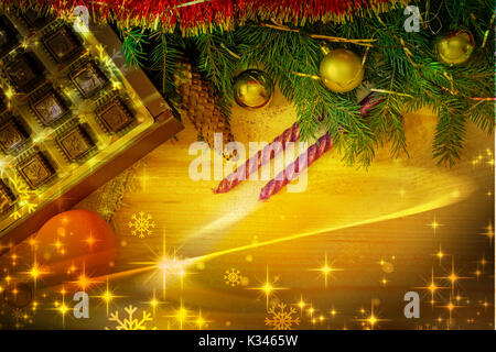 On a wooden table beautifully set decorations and gifts for Christmas, the New year pine branches, cones, shiny balls, candles, confetti. Stock Photo