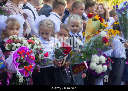 Adygea, Russia - September 1, 2017: children with bouquets of flowers enrolled in the first grade with high school students at school the solemn ruler Stock Photo