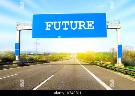 Blue freeway sign over the road on sunny day with word Future on it Stock Photo