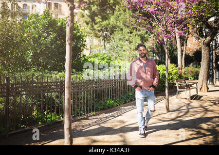 A photo of young man walking down the alley in the park. Stock Photo