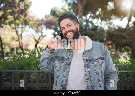 A photo of young, handsome man talking on the mobile and laughing. Stock Photo