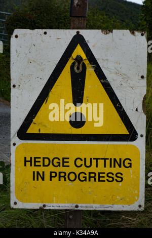 Hedge cutting in progress sign. Powys. Wales Stock Photo