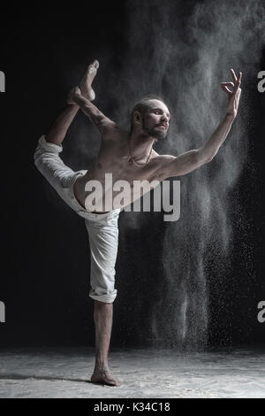 Flexible yoga man practices yoga or pilates, performing Natarajasana Stock Photo