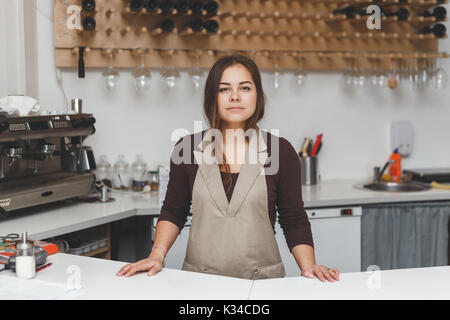 Portrait of pretty young waitress standingin cafeteria behind the counter Stock Photo