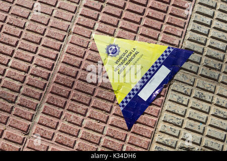 Spanish police sticker placed on pavement informing that a car has been towed away. Stock Photo