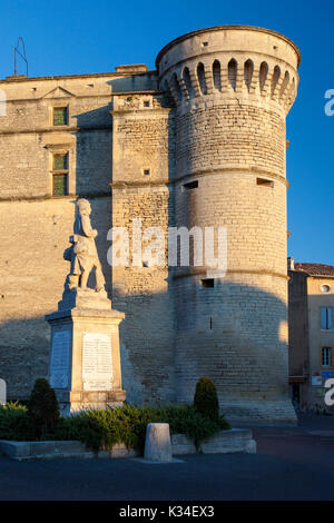 World Wars I and II memorial in the town center, with Castle - le Chateau de Gordes towering over, Gordes, Provence France Stock Photo