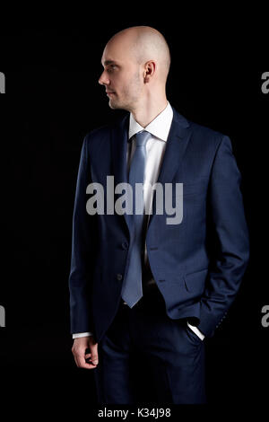 Studio shot of young man in suit looking right on black background. Stock Photo