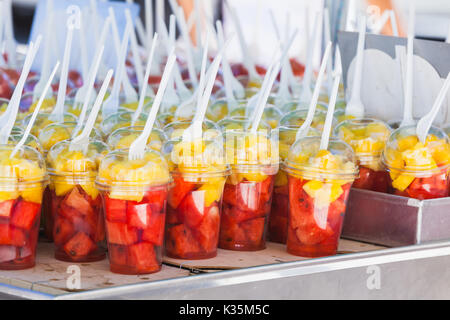 Fresh fruits sorted in plastic cups with forks. Street dessert shop in Lisbon, Portugal. Close-up photo with selective focus Stock Photo