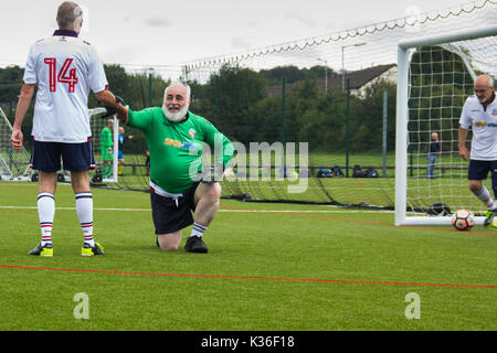 Heywood, Greater Manchester, UK. 1st September 2017. Today saw the kick-off of the second season for the Greater Manchester Over 60s Walking Football league at Heywood Sports Centre. The Bolton Wanderers B goalie receives a welcome helping hand to his feet as the defender fishes the fourth goal scored by Wakefield Wanderers out of the back of the net. Walking Football is one of the fastest growing areas of organised football in the UK, aimed at increasing health and fitness through physical activity in the over 50s, encouraged by football clubs, health professionals and Football Association. Stock Photo