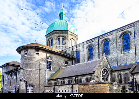 A flock of pigeons by the green verdigris-covered copper dome of St. Joseph's Roman Catholic Church, Highgate Hill, London, UK Stock Photo