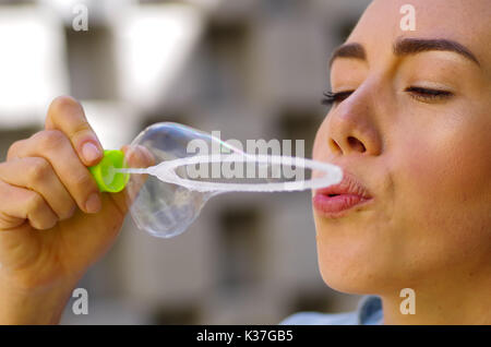 Woman playing with soap bubbles on a summer nature, in a blurred nature background Stock Photo