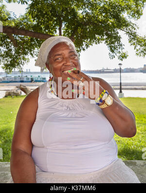 Santeria faith fortune teller with smoking cigar, Cuban woman following the Santeria religion in Regla, Cuba Stock Photo