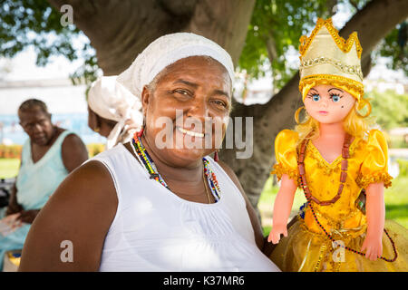 Santeria faith fortune teller with Santeria doll, Cuban woman following the Santeria religion in Regla, Cuba Stock Photo