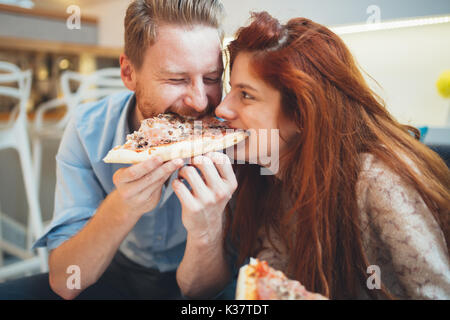 Couple sharing pizza and eating Stock Photo