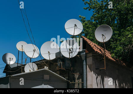 Many satellite dishes on the roof of the house. Stock Photo