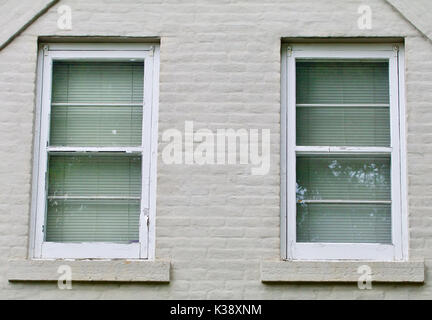 Gray brick wall with two white windows Stock Photo