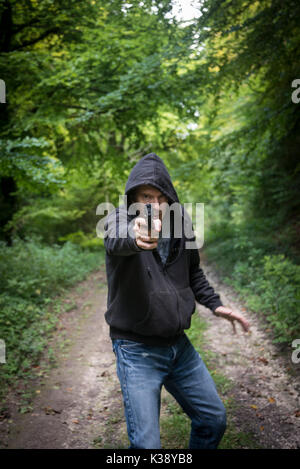 man pointing a gun wearing a hoodie Stock Photo