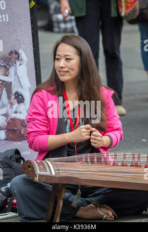 A young Korean musician playing a traditional stringed instrument at the Edinburgh Festival Fringe Stock Photo