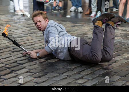 A fire eater and juggler performing in the street at the Edinburgh Festival Fringe on the Royal Mile Stock Photo