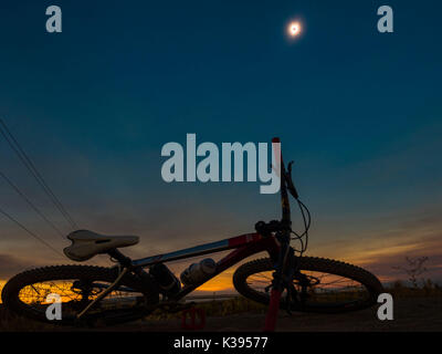 A bicycle is shown in the foreground during a total eclipse as seen from Madras, Oregon on August 21, 2017. Photo by Francis Specker Stock Photo