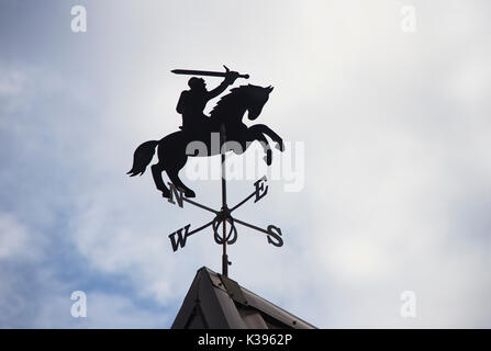 metal weather vane in a shape of knight on horse on a rooftop Stock Photo