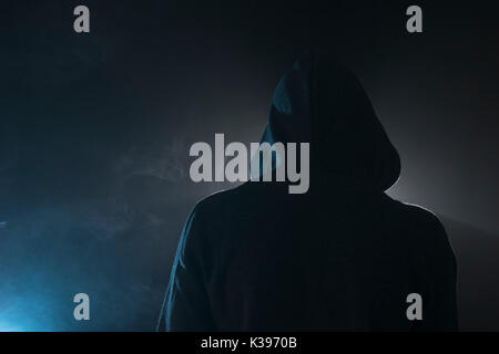Isolated young man standing in a dark mysterious place. Stock Photo