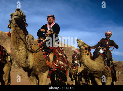 King Abdullah II of Jordan rides a camel at Wadi Rum dressed in traditional Jordanian clothing while filming for the travel documentary Jordan: the Royal Tour. Stock Photo